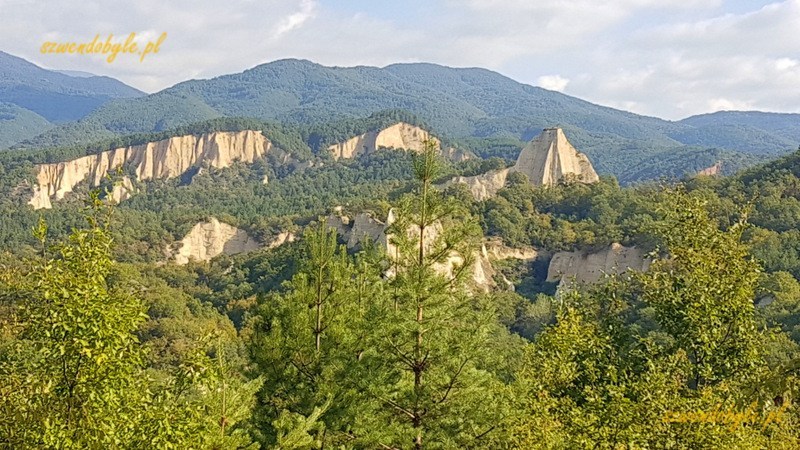 Bułgaria, skalne piramidy na tle gór i nieba.