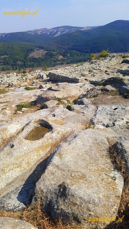 Bułgaria, Perperikon - widok ruiny, kamienie z wyżłobieniami, w tle góry. 20230930_113241-ink