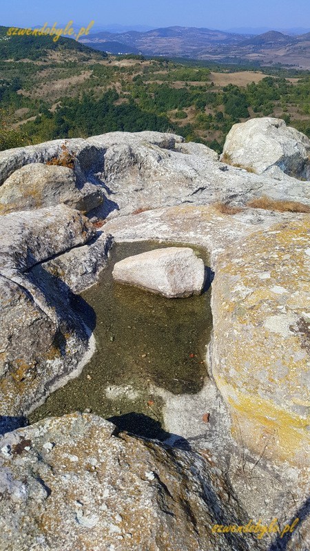Bułgaria, Perperikon - widok na kamienie z wyżłobieniami na tle gór. 20230930_114912-ink