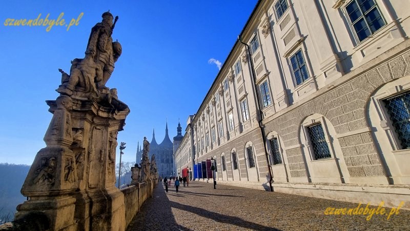 Czechy, Kutn&aacute; Hora. Widok w kierunku kościoła św. Barbary. Po prawej kolegium jezuickie, po lewej jedna z figur zdobiących balustradę. 20251227_112536-ink