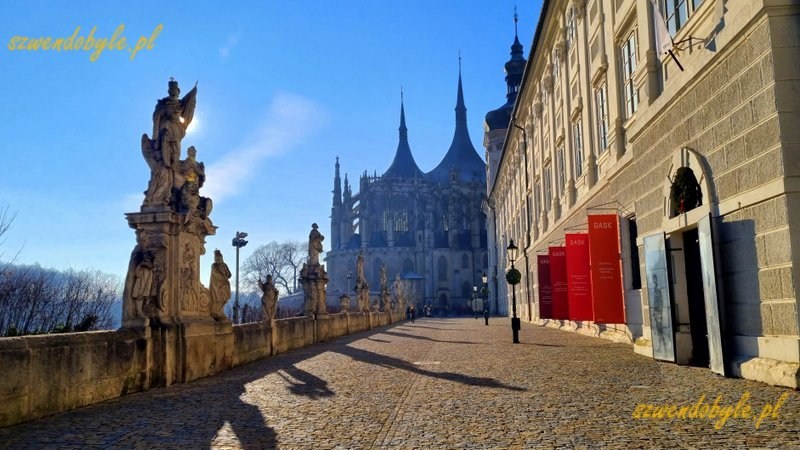 Czechy, Kutn&aacute; Hora. Widok w kierunku kościoła św. Barbary. Po prawej kolegium jezuickie, po lewej jedna z figur zdobiących balustradę. 20251227_112743-ink
