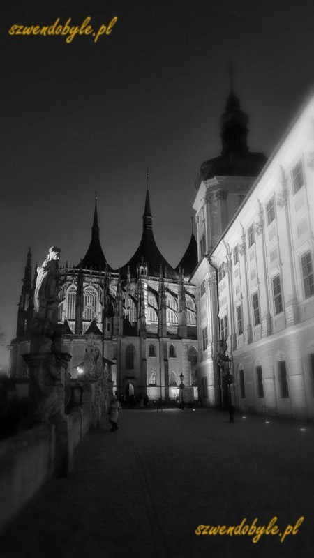 Czechy, Kutn&aacute; Hora. Widok w kierunku kościoła św. Barbary. Po prawej kolegium jezuickie, po lewej jedna z figur zdobiących balustradę. Zdjęcie czarno-białe, wykonane po zmroku. 20251227_164810-ink