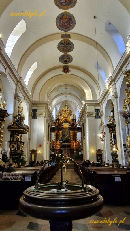 Praga. Wnętrze - nawa gł&oacute;wna kościoła Panny Marii Zwycięskiej. Na pierwszym planie kropielnica. 20251226_095030-ink