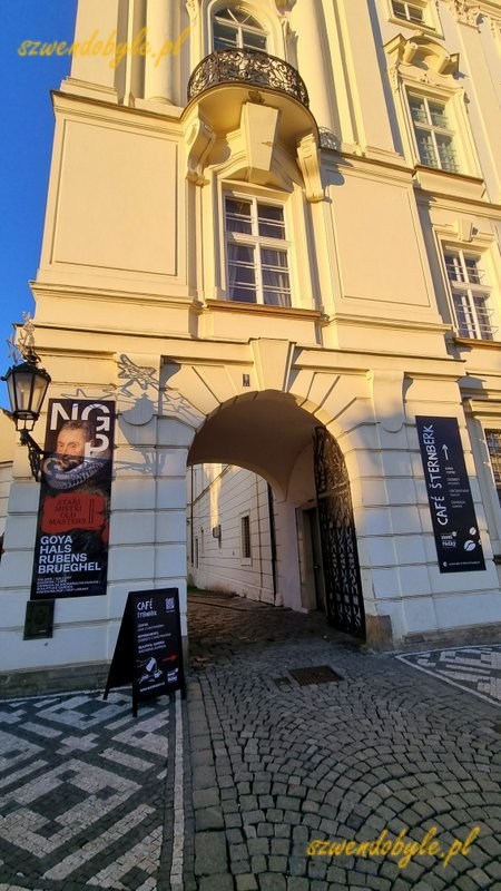 Praga. Brama wkomponowana w budynek pałacu arcybiskupiego stanowi przejście do wąskiej uliczki wiodącej do pałacu Sternberg&oacute;w. 20251226_145651-ink