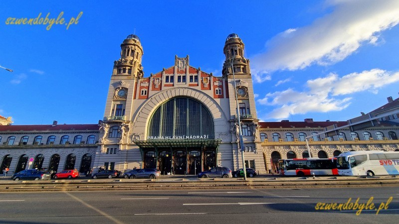 Praga dworzec gł&oacute;wny - Praha hlavn&iacute; n&aacute;draž&iacute;. Zdjęcie z zewnątrz, z drugiej strony ulicy Wilsonowej na gmach dworca charakterystycznymi wieżami. Boczne skrzydła dworca nie mieszczą się w kadrze. 20251228_143351-ink