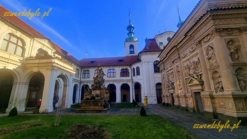 Praga, Loreta czyli kompleks pielgrzymkowy epoki baroku. Dziedziniec, po prawej domek loretański zdobiony wieloma płaskorzeźbami. 20251226_103925-ink