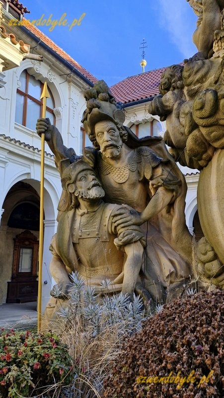 Praga, Loreta czyli kompleks pielgrzymkowy epoki baroku. Fragment dużej kamiennej rzeźby na dziedzińcu, postaci 2 rzymskich żołnierzy. 20251226_104949-ink