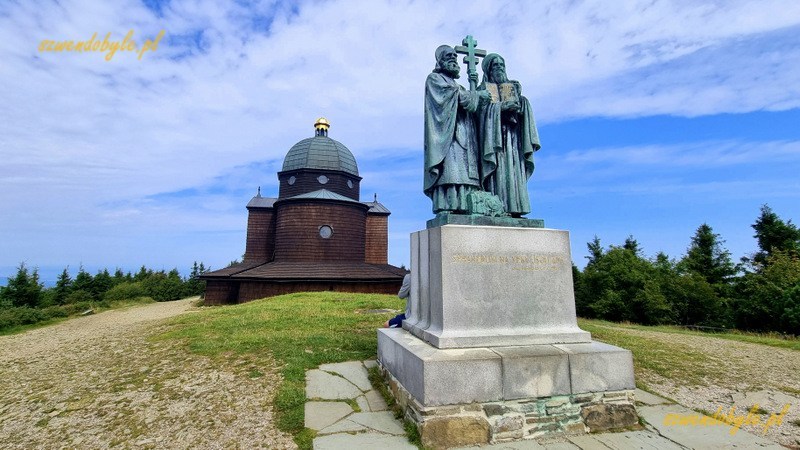 Czechy, Pustevny. Pomnik świętych Cyryla i Metodego na g&oacute;rze Radho&scaron;ť (pol. Radhoszcz). Za pomnikiem drewniana kaplica. 20250809_110354kp-ink