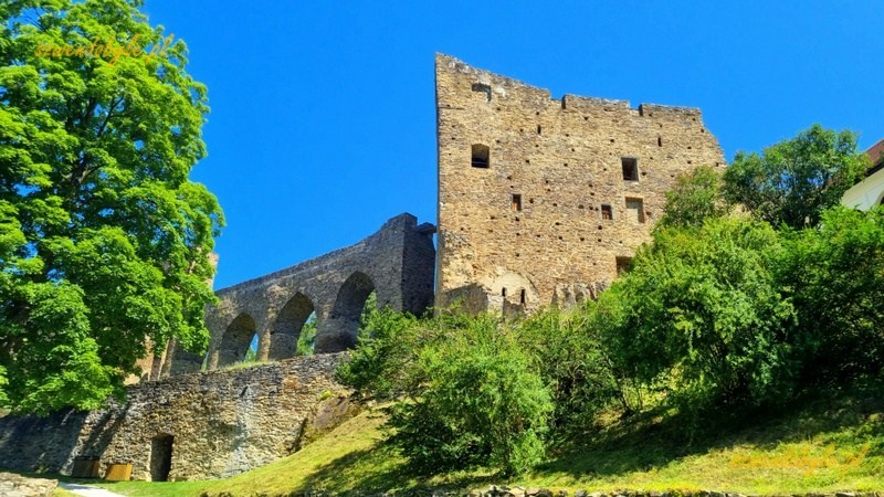 Zamek Velhartice, Czechy. Widok na wieżę mieszkalna, po lewej kamienny most i drzewa. 20250620_112512-ink