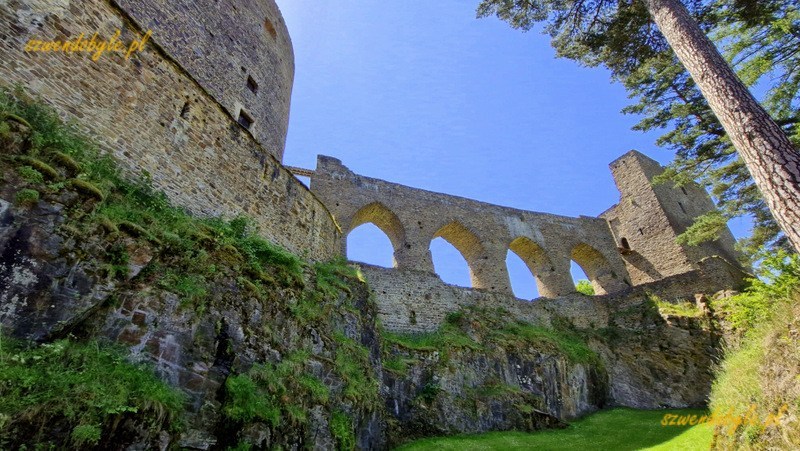 Zamek Velhartice, Czechy. Widok na wieżę mieszkalną (Rajski Dom) i kamienny most z fosy otaczającej zamek. 20250620_134812-ink