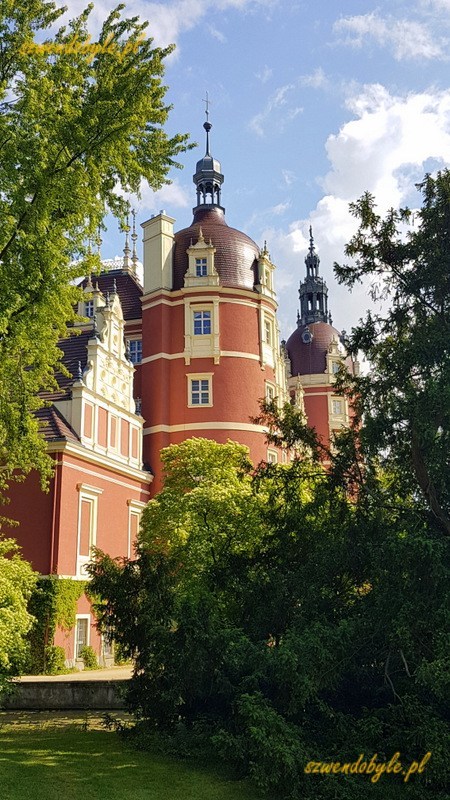 Bad Muskau, Neues Schloss / Mużaków. Nowy Zamek. Okrągła, ośwetlona słońcem wieża wyłania się zza krzewów. 20230614_163317-ink