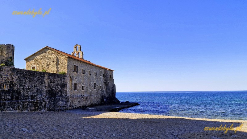 Czarnogóra, Budva. Na piaszczystm brzegu morza ściana zewnętrzna cerkwi połączona z murami Starego Miasta. 20250502_083438-ink