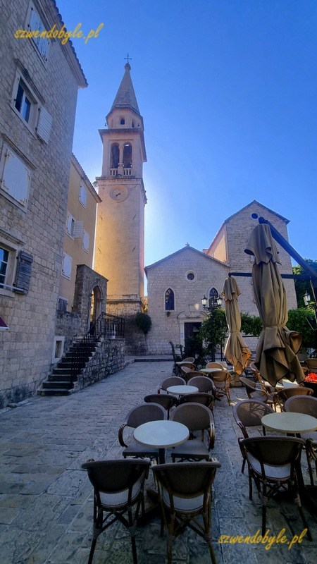 Czarnogóra, Budva. Stoliki nieczynnej jeszcze restauracji i w tle dzwonnica kościoła św. Jana Chrzciciela. 20250502_083727-ink
