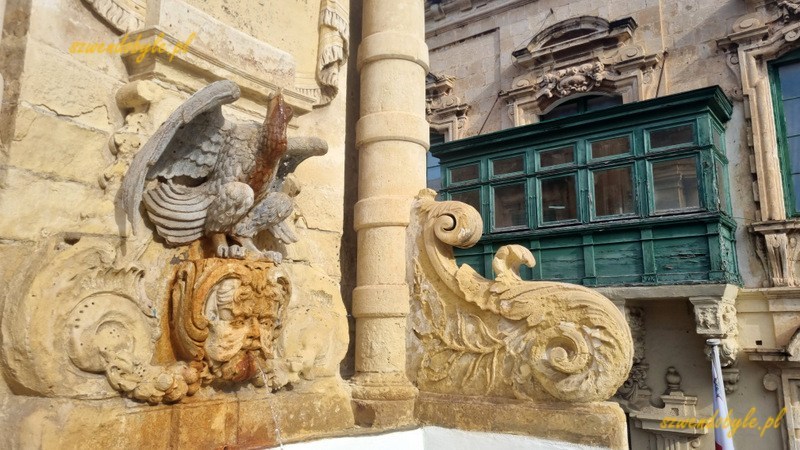 Balkony na Malcie, Valletta. Zielony balkon, na pierwszym planie narożnik innego budynku z kamiennym orłem i ozdobami z piaskowca.