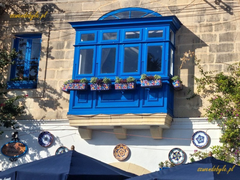 Balkony na Malcie, Valletta. Niebieski balkon, pod nim ceramiczne ozdoby w formie malowanych talerzy.