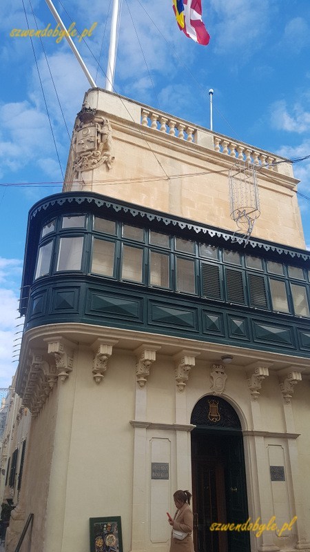 Balkony na Malcie, Rabat. Widok prestiżowej narożnej kamienicy z zielonym balkonem wzdłuż całej fasady budynku.