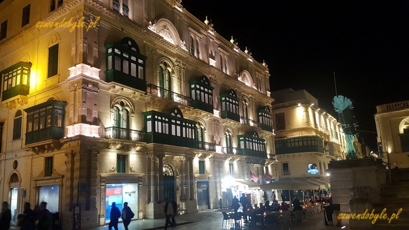 Balkony na Malcie, Valletta. Nocny widok prestiżowej kamienicy przy głównym deptaku. Nagromadzenie zielonych balkonów.