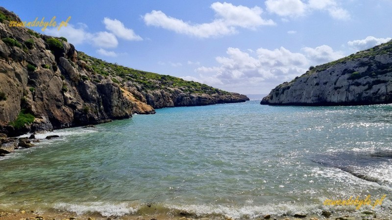 Malta, wyspa Gozo. Widok z plaży ix-Xini w kierunku wąskiego wyjścia w morze pomiędzy skałami. 20250303_120003-ink