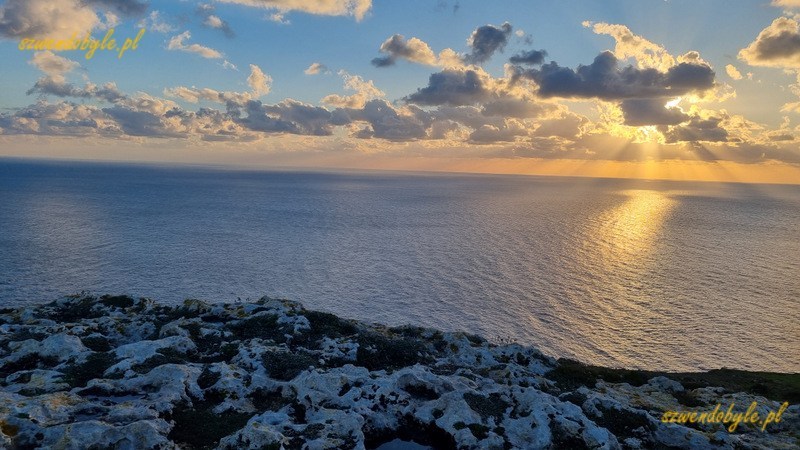 Malta, zachód słońca z klifów Dingli. W dolnej części skalna nawierzchnia pełna dziur i nierówności.