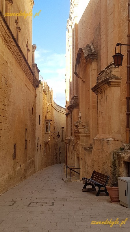 Mdina, wąska kamienna uliczka pomiędzy kamiennymi ścianami.