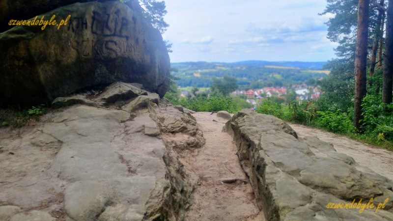 Ciężkowice. Skały w rezerwacie "Skamieniało miasto". Zza skały widok na miasto. 20240720_145114-ink