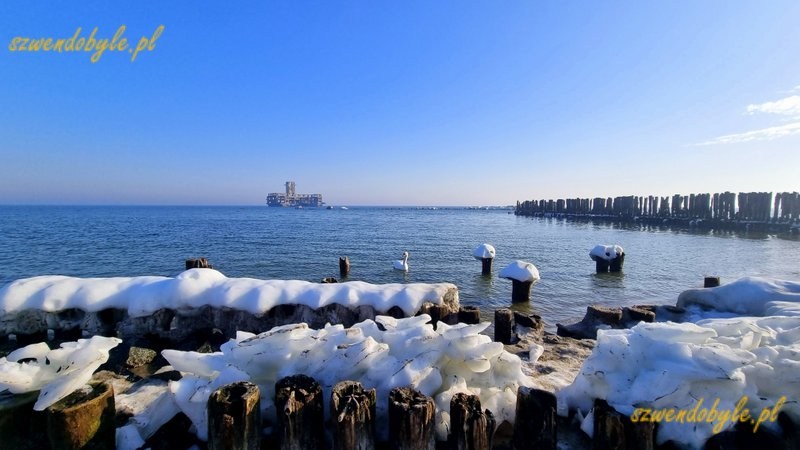 Gdynia, Babie Doły. Widok na pale wbite w dno morza pokryte lodem. Pośrodku zdjęcia torpedownia. 20260228_092010-ink