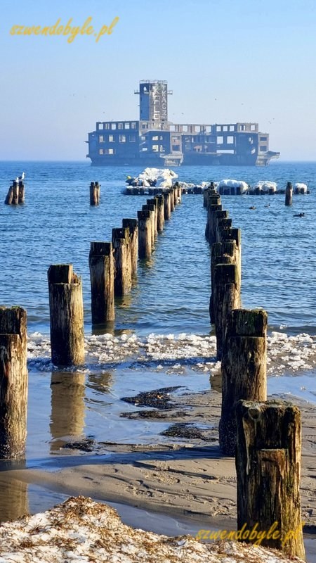 Gdynia, Babie Doły. Widok na szpaler pali wbitych w dno morza. Pośrodku zdjęcia torpedownia. 20260228_092601-ink