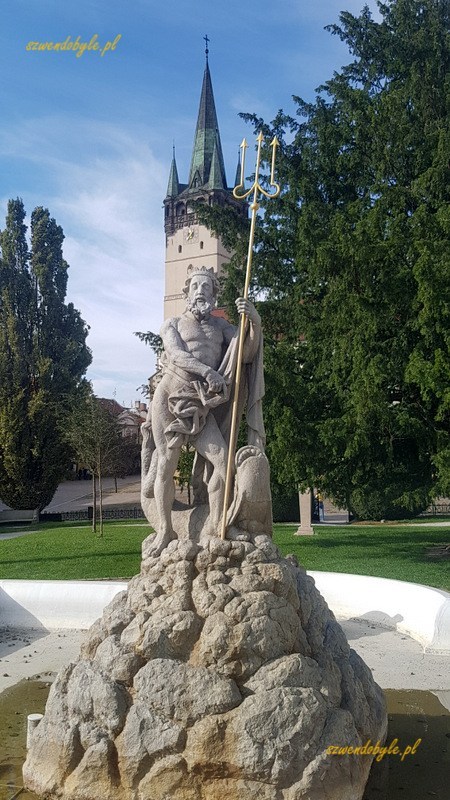 Preszów, ulica Hlavna, rzeżba z fontanny Neptuna na tle wieży kościoła św. Mikołaja.