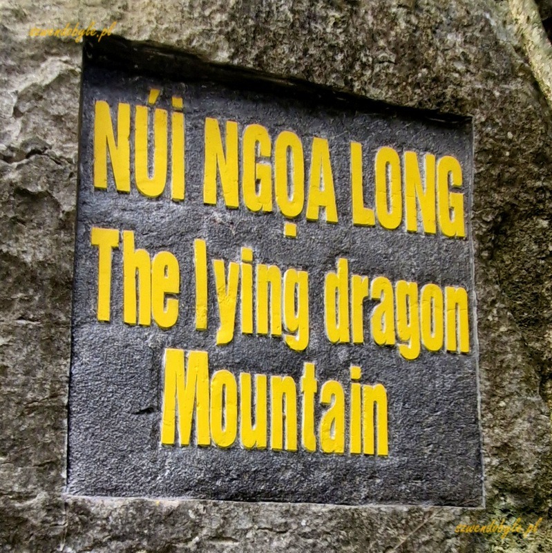 Wietnam, region Ninh Binh. Ż&oacute;łty napis w skale w języku wietnamskim i angielskim "The lying dragon Mountain". 20251111_102929-ink