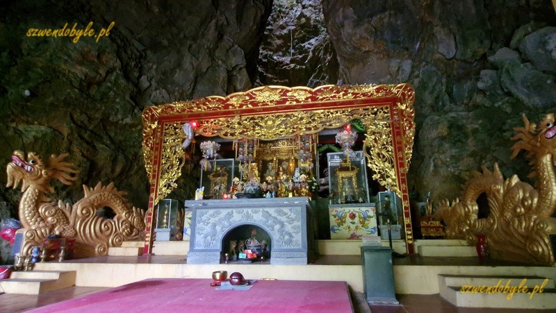 Tam Coc, Vietnam. Świątunia Thien Huong w jaskini. Złoty ołtarz, bo bokach dwa złote smoki. Z ołtarzem smuga światła dziennego,kt&oacute;re wpada przez otw&oacute;r w g&oacute;rnej części skały. 20251111_150847-ink